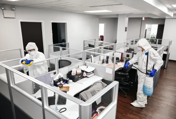 Technician performing disinfection misting in an office to prevent virus spread