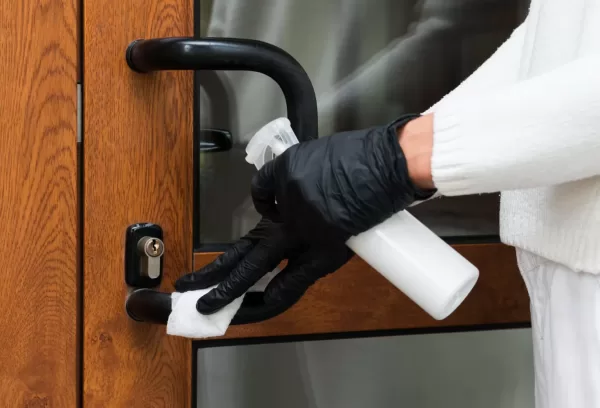using high-level disinfectant to wipe door handle and kill viruses and bacteria